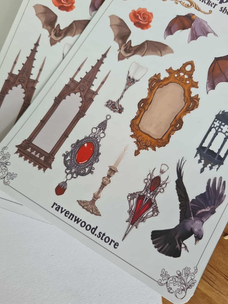 May include: Sheets of stickers featuring gothic and Victorian-inspired illustrations. Designs include bats, roses, ornate mirrors, jewelry, and architectural elements. The text "ravenwood.store" is printed on the stickers.