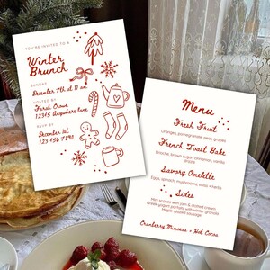 May include: Two white cards with red text and illustrations. One card reads "Winter Brunch" with event details. The other card is a menu with "Fresh Fruit" and "French Toast Bake" listed. A festive winter theme is present.