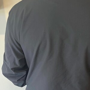 May include: A black jacket with a collared neckline and long sleeves.