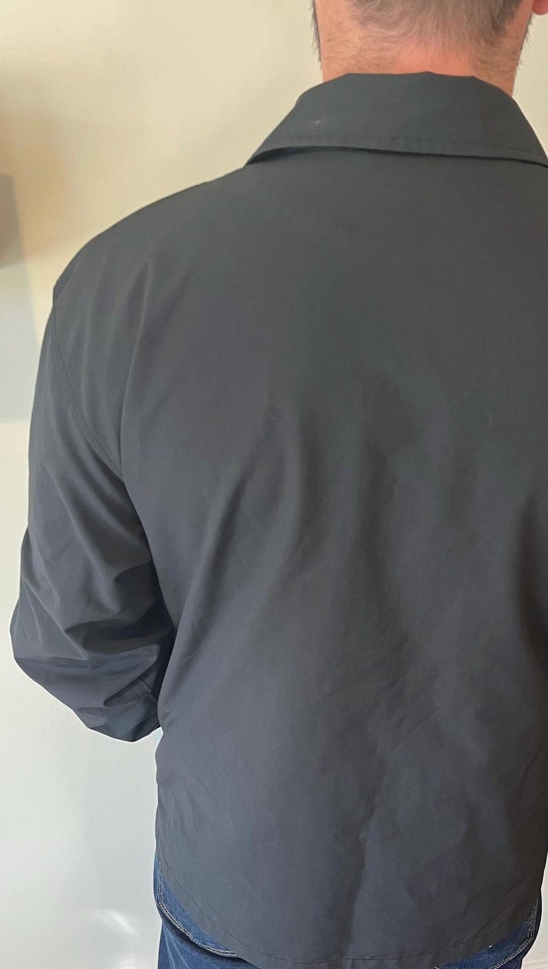 May include: A black jacket with a collared neckline and long sleeves.