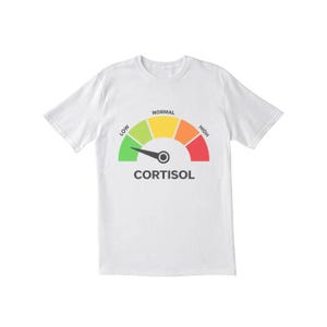 May include: White t-shirt featuring a cortisol level gauge design. The gauge displays a spectrum from green (low) to red (high), with "Normal" in yellow. The word "CORTISOL" is printed below the gauge in black.