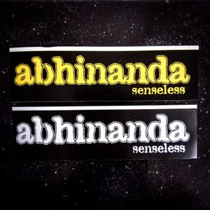 May include: Two black and white stickers with the text "abhinanda senseless" in a stylized font. The top sticker has yellow text and the bottom sticker has white text.