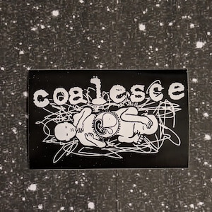 May include: Black and white sticker with the word "coalesce" in bold white letters. The sticker features a stylized illustration of two figures intertwined, with one figure holding a circular object.