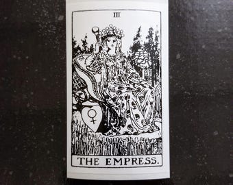 以下が含まれることがあります： タロットカード「女帝」の白黒イラスト。カードには、王冠をかぶった女性が玉座に座り、笏を手にしている様子が描かれている。カードの番号「III」はカードの上部にあり、「女帝」という文字はカードの下部にある。