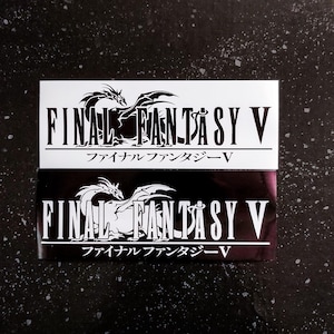 Könnte beinhalten: Zwei Aufkleber mit einem Schwarzweißbild eines Drachen und dem Text "FINAL FANTASY V" in Weiß. Der Text "ファイナルファンタジーV" ist ebenfalls in Japanisch enthalten.