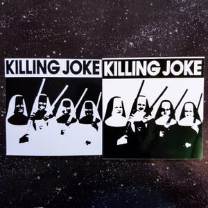 Puede incluir: Imagen en blanco y negro de una banda llamada Killing Joke. La imagen presenta seis figuras vestidas con hábitos de monja y sosteniendo rifles. El nombre de la banda está impreso en letras blancas en negrita sobre un fondo negro.