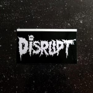 Op de afbeelding: Zwart-witte sticker met het woord "DISRUPT" in een gestileerd, gekarteld lettertype.