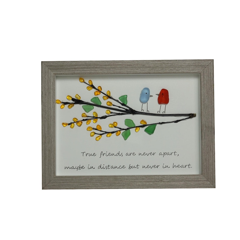 May include: A framed artwork featuring a branch with yellow and green glass leaves and two glass birds, one blue and one red. The quote "True friends are never apart, maybe in distance but never in heart." is written below the branch.