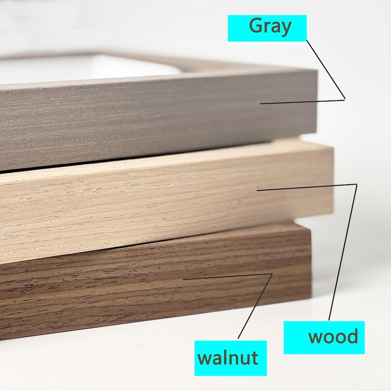 May include: Close-up of three picture frames showing different wood finishes: gray, walnut, and wood.