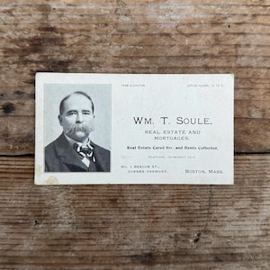 Puede incluir: Una tarjeta de visita vintage en blanco y negro con una foto de un hombre con bigote. El texto dice "WM. T. SOULE, REAL ESTATE AND MORTGAGES. Real Estate Cared for, and Rents Collected. TELEPHONE, HAYMARKET 5714. NO. 1 BEACON ST., CORNER TREMONT. BOSTON, MASS."
