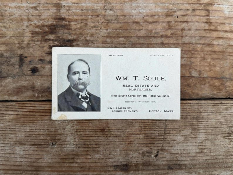 Puede incluir: Una tarjeta de visita vintage en blanco y negro con una foto de un hombre con bigote. El texto dice "WM. T. SOULE, REAL ESTATE AND MORTGAGES. Real Estate Cared for, and Rents Collected. TELEPHONE, HAYMARKET 5714. NO. 1 BEACON ST., CORNER TREMONT. BOSTON, MASS."