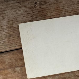 Puede incluir: Una tarjeta blanca en blanco con una inscripci&oacute;n manuscrita en la parte posterior.