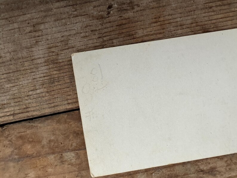 Puede incluir: Una tarjeta blanca en blanco con una inscripci&oacute;n manuscrita en la parte posterior.