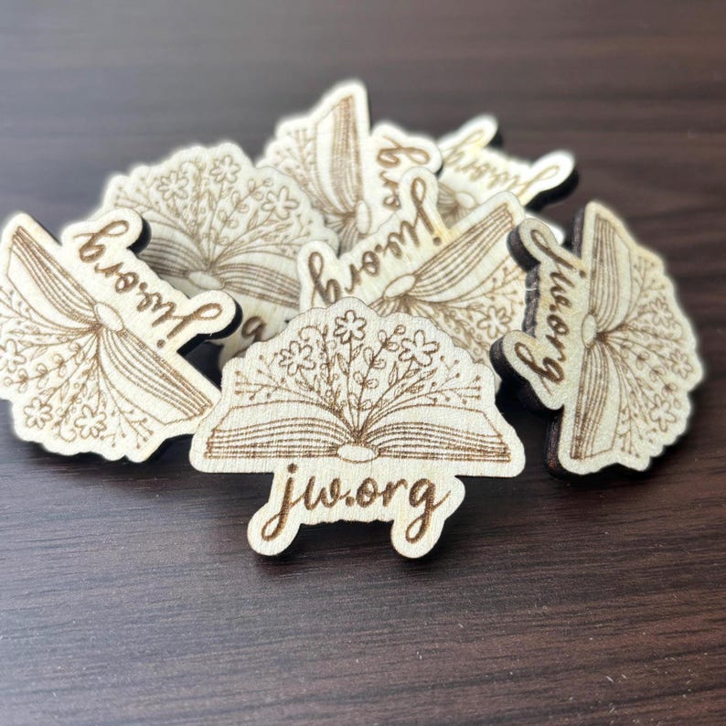 May include: A set of wooden book-shaped ornaments with floral designs and the text "bloom!" and "jw.org".