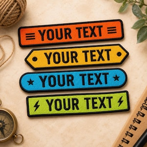 Peut inclure: Quatre écussons brodés rectangulaires avec des bordures noires et le texte noir YOUR TEXT. L'écusson du haut est orange avec des lignes, le deuxième est jaune avec des points, le troisième est bleu avec des étoiles et le bas est vert citron avec des éclairs.