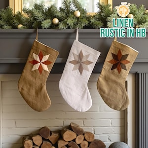 May include: Three rustic linen Christmas stockings in shades of brown and white hang from a mantel. Each stocking features a star design in varying colors. The text "LINEN RUSTIC IN HB" is visible in the upper right corner.