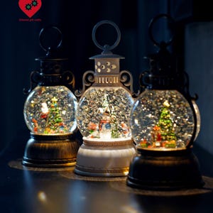 Weihnachtslaterne Schneekugel Spieluhr - Beleuchten Sie Urlaub Glitter Dome mit Weihnachtsmann, Schneemann & Baum, festliches Winterdekorationsgeschenk