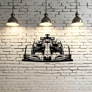 Op de afbeelding: Zwarte metalen wandkunst van een Formule 1-raceauto. Het kunstwerk is bevestigd aan een witte bakstenen muur en wordt verlicht door drie hanglampen. De auto is een gedetailleerd silhouet.