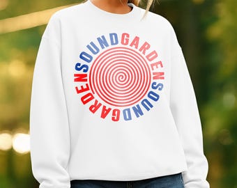 May include: White sweatshirt with a circular graphic that reads "SOUNDGARDEN" in red and blue lettering. The graphic features a spiral design in the center. The sweatshirt is paired with denim shorts.