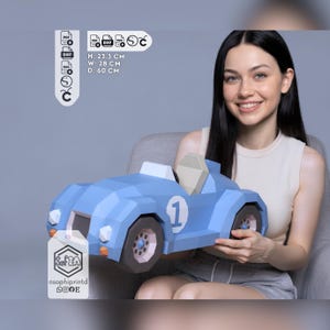 May include: A light blue low-poly papercraft race car model with the number 1 on the side. The model features dark gray wheels, a white windshield, and a beige seat. Dimensions are 23.3 cm high, 28 cm wide, and 60 cm deep as indicated in the image.