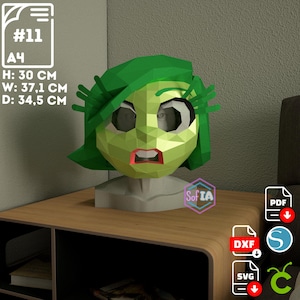 Può includere: Un modello di carta verde di un personaggio con capelli verdi e un'espressione sorpresa. Il modello è alto 30 cm, largo 37,1 cm e profondo 34,5 cm. Il modello è seduto su un tavolo di legno. L'immagine include anche testo per i formati di file PDF, DXF e SVG.