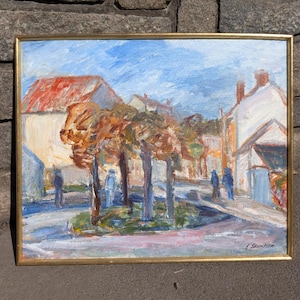 Könnte beinhalten: Ölgemälde in einem goldenen Rahmen, das eine europäische Dorfszene darstellt. Das Kunstwerk zeigt Gebäude mit roten und weißen Fassaden, Bäume mit orangefarbenem und braunem Laub und Figuren auf einer Straße unter blauem Himmel.