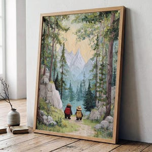 May include: A framed wall art print depicting a watercolor landscape of a forest path leading toward snow-capped mountains. Two small bears wearing hats and backpacks walk along the trail, surrounded by tall pine trees and rocky terrain.