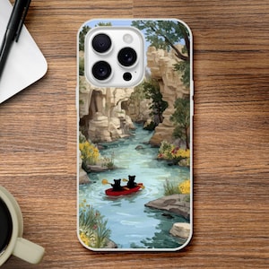May include: White phone case featuring a scenic illustration of a river canyon. A red canoe with two black bear figures is in the water. The canyon walls are tan and green, with a blue sky above. The phone case is on a wooden surface.