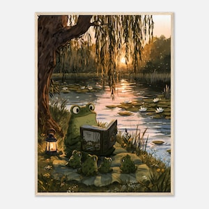 Op de afbeelding: Een ingelijste kunstdruk met een grote groene kikker die een open boek voorleest aan vier kleinere kikkers bij een vijver tijdens zonsondergang. Een treurwilg hangt over de scène en een kleine brandende lantaarn staat bij de kikkers tussen de lelies.