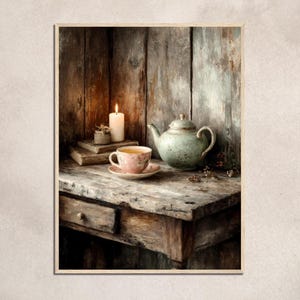 Puede incluir: Pintura de naturaleza muerta con una vela encendida, libros y una taza de té y platillo con diseño floral. Una tetera verde se encuentra junto a la taza de té sobre una mesa de madera rústica.