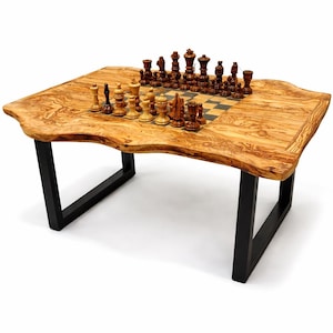 May include: A wooden chess table with a live edge design. The table features a natural wood grain finish and black metal legs. Chess pieces are arranged on the built-in chessboard. The table is a unique piece of furniture.