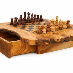 May include: A wooden chess set with a live edge design. The chess board is made of a light-colored wood with a dark checkered pattern. The chess pieces are brown and beige. A drawer is built into the base of the chess set.