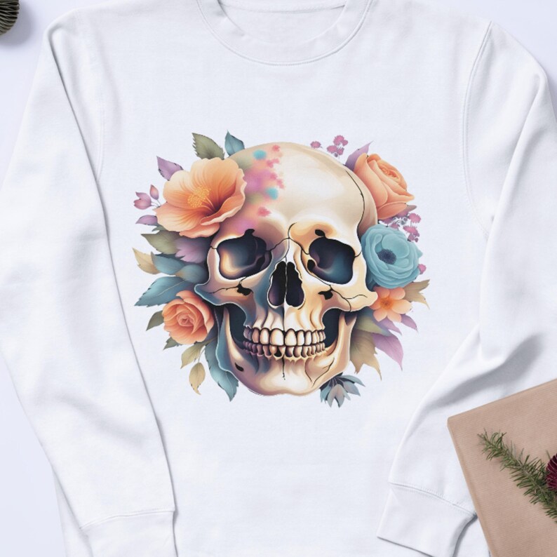 Puede incluir: Sudadera blanca con un dise&ntilde;o floral colorido que rodea una calavera blanca. La calavera tiene un dise&ntilde;o pintado en un lado.