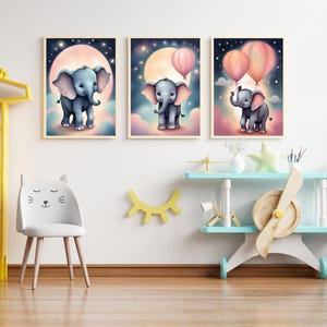 Puede incluir: Tres impresiones enmarcadas con ilustraciones de elefantes con globos rosas sobre un fondo de cielo nocturno estrellado. Los elefantes son grises y tienen orejas grandes. Los globos flotan en el aire sobre los elefanten. Las impresiones son perfectas para una guarder&iacute;a o una habitaci&oacute;n infantil.