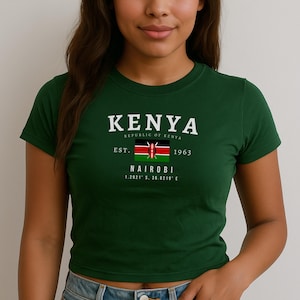 May include: A green t-shirt with a white graphic print of the text "KENYA REPUBLIC OF KENYA EST. 1963 NAIROBI 1.2921&deg; S, 36.8219&deg; E" and a small image of the Kenyan flag.