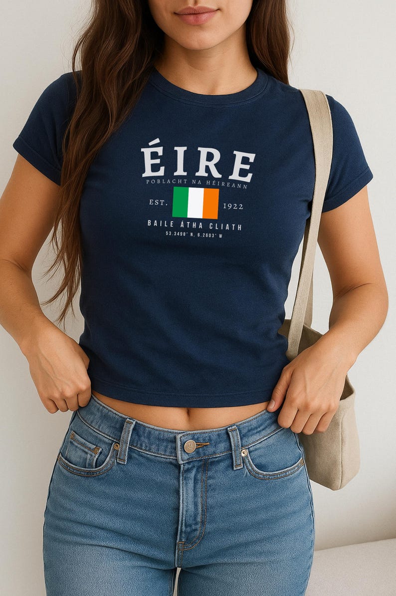 May include: A navy blue t-shirt with a white graphic of the Irish flag and the text "&Eacute;IRE Poblacht na h&Eacute;ireann Est. 1922 Baile &Aacute;tha Cliath 53.3408&deg; N, 6.2603&deg; W"