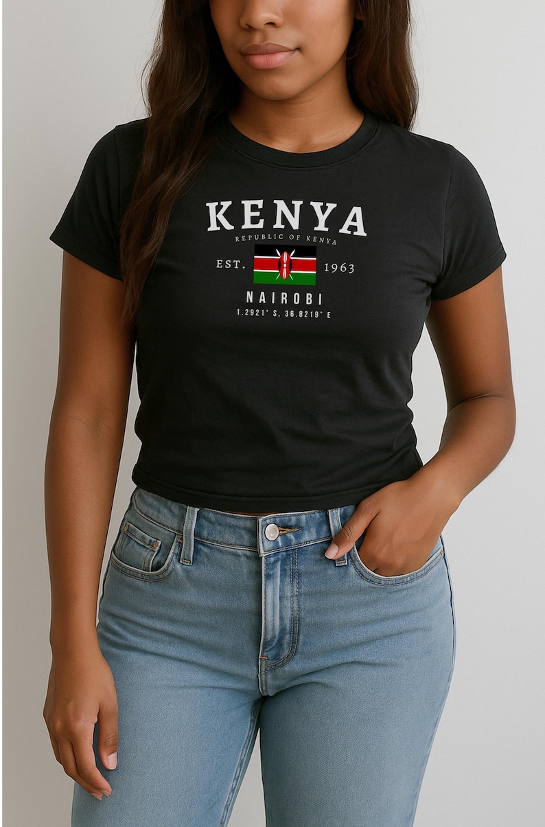 May include: Black t-shirt with a white graphic design featuring the text "KENYA", "REPUBLIC OF KENYA", "EST. 1963", "NAIROBI", and "1.2921&deg; S, 36.8219&deg; E". The graphic also includes the flag of Kenya.