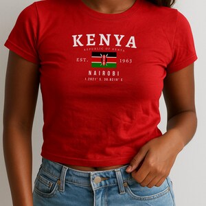 May include: Red cropped t-shirt with a white graphic print of the Kenyan flag and the text "KENYA REPUBLIC OF KENYA EST. 1963 NAIROBI 1.2821&deg; S, 36.8219&deg; E"