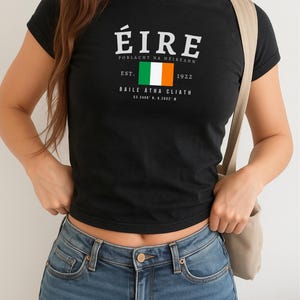 May include: Black t-shirt with a white graphic print of the Irish flag and the text "&Eacute;IRE POBlacht NA h&Eacute;ireann EST. 1922 BAILE &Aacute;THA CLIATH 53.3406&deg; N, 6.2603&deg; W"