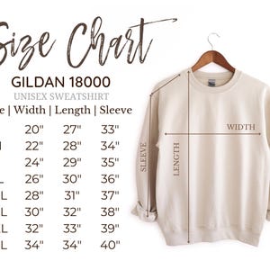 Puede incluir: Una sudadera unisex Gildan 18000 color crema en una percha de madera. La imagen incluye una tabla de tallas con medidas en pulgadas para el ancho, el largo y el largo de la manga, que van desde la talla S hasta la 5XL. El texto "Size Chart" est&aacute; en la parte superior.