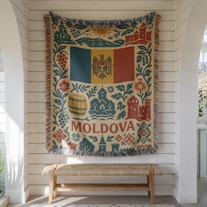 Könnte beinhalten: Ein gewebtes Wandtuch mit der Flagge Moldawiens, einem zentralen Emblem und dem Wort "Moldova" darunter. Das Wandtuch hat einen beigen Hintergrund mit roten, blauen und gelben Akzenten und ist gefranst. Es hängt an einer weißen Wand.