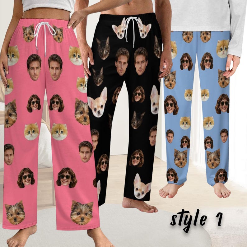 May include: Three pairs of pajama trousers in pink, black, and light blue, each patterned with a repeating design of faces. The pink trousers feature cat, dog, and human faces. The black trousers have cat, dog, and human faces. The blue trousers have cat, dog, and human faces.