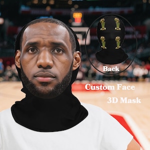 Pode incluir: Uma máscara facial 3D preta com uma imagem personalizada de um jogador de basquete. A máscara tem um cachecol de pescoço preto e a parte de trás da máscara tem um design de vários troféus de basquete. O texto "Custom Face 3D Mask" está impresso na imagem.