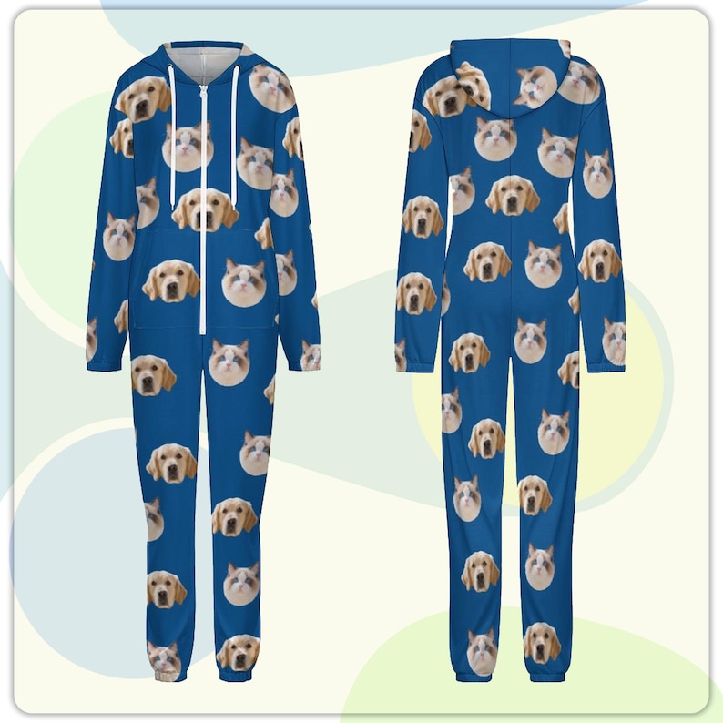 May include: A blue hooded jumpsuit featuring a repeating pattern of dog and cat faces. The jumpsuit has a front zipper and long sleeves. The design includes various breeds of dogs and cats, creating a playful and unique look.
