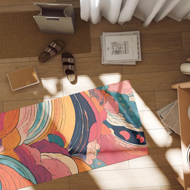 May include: A colorful yoga mat with a swirling abstract pattern in shades of pink, orange, blue, and green. The mat is laid out on a wooden floor with natural light shining on it.