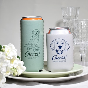 May include: Two beverage can coolers. One is light green with a dog illustration and the text "Cheers! Love, Joey". The other is white with a dog illustration and the text "Cheers! Love, Ravioli".