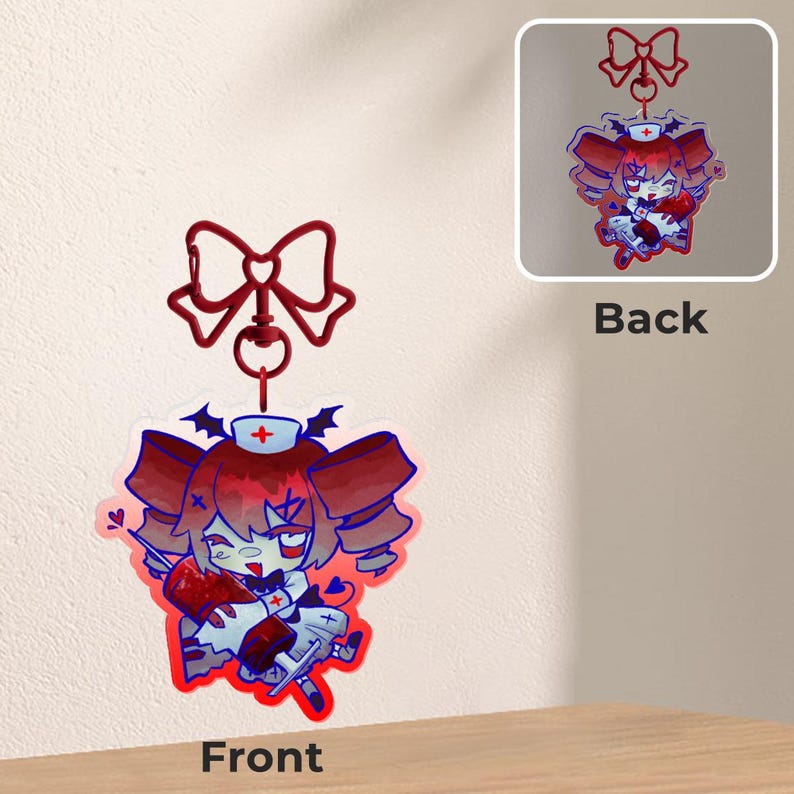 May include: A red and white anime-style nurse charm with a red bow and a lobster clasp. The charm features a cartoon character with red hair, a nurse's cap, and a syringe. The back of the charm is also visible.