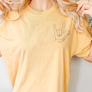 Autism awareness shirt with hand sign design and quote “Love Needs No Words.” Perfect SPED teacher gift, autism mom tee, or support top for awareness events.