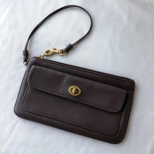 Pochette zippée portefeuille Legacy Turn Lock Wristlet en cuir marron acajou Coach