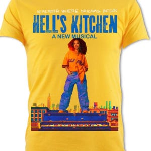 Może przedstawiać: Musztardowa koszulka z niebieskim napisem "REMEMBER WHERE DREAMS BEGIN" i "HELL'S KITCHEN A NEW MUSICAL". Koszulka przedstawia obraz osoby przed fortepianem i panoramą miasta.